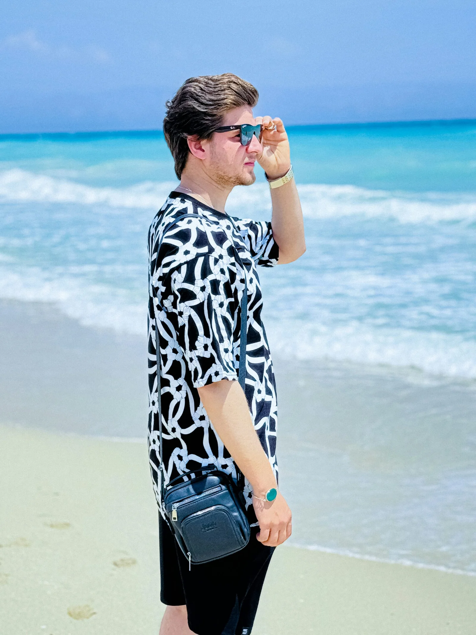 A man standing on a beach next to the ocean